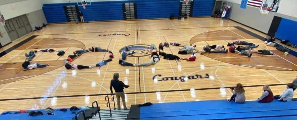 Group forming letters on gymnasium floor